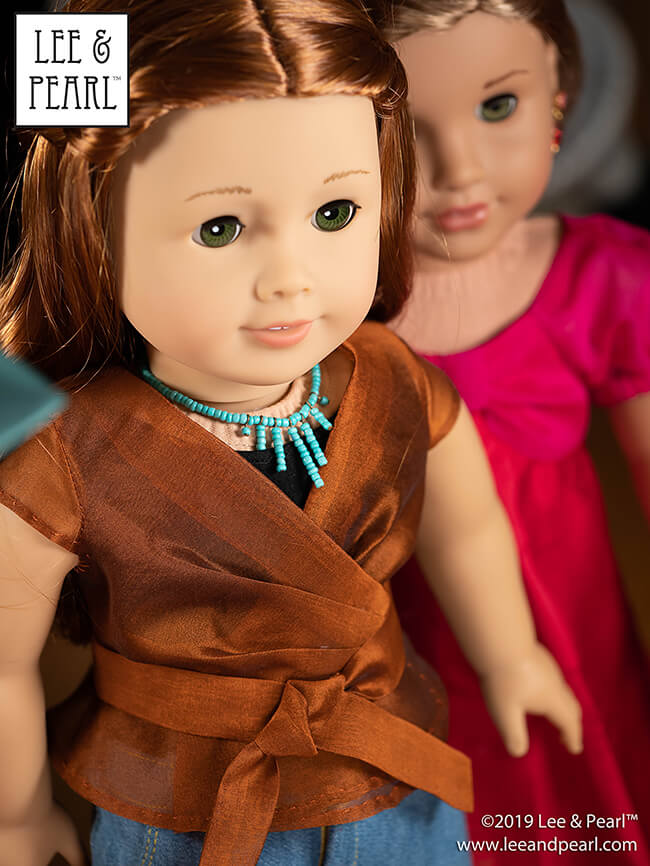 We made our American Girl doll’s shimmering silk organza blouse using materials from our COMING SOON silk fabric kits and Lee & Pearl Pattern 1031: Classic Wrap Dress and Peplum Top for 18 Inch Dolls. Get this pattern — and the unitard and denim skirt patterns as well — in the Lee & Pearl Etsy store.