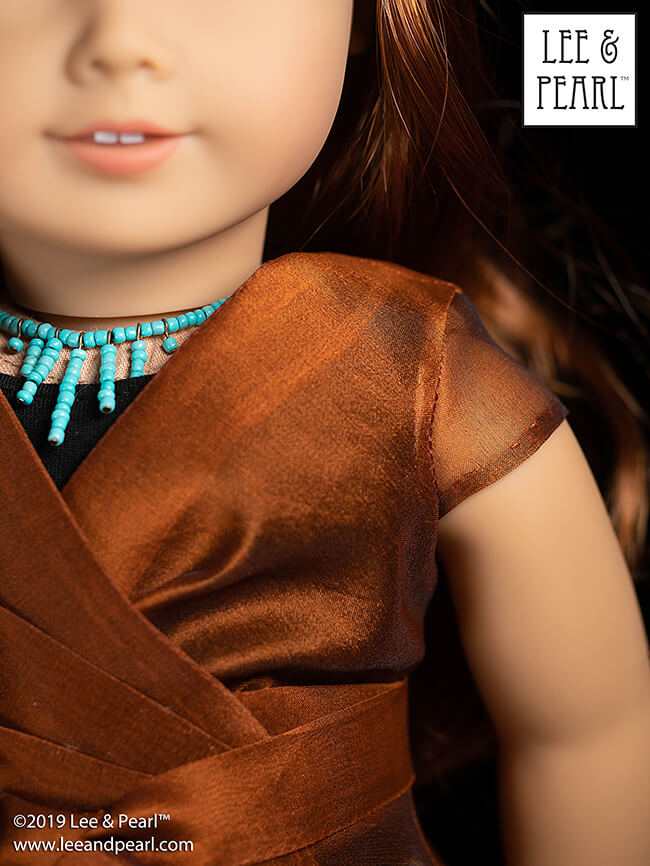 We made our American Girl doll’s shimmering silk organza blouse using materials from our COMING SOON silk fabric kits and Lee & Pearl Pattern 1031: Classic Wrap Dress and Peplum Top for 18 Inch Dolls. Get this pattern — and the unitard and denim skirt patterns as well — in the Lee & Pearl Etsy store.