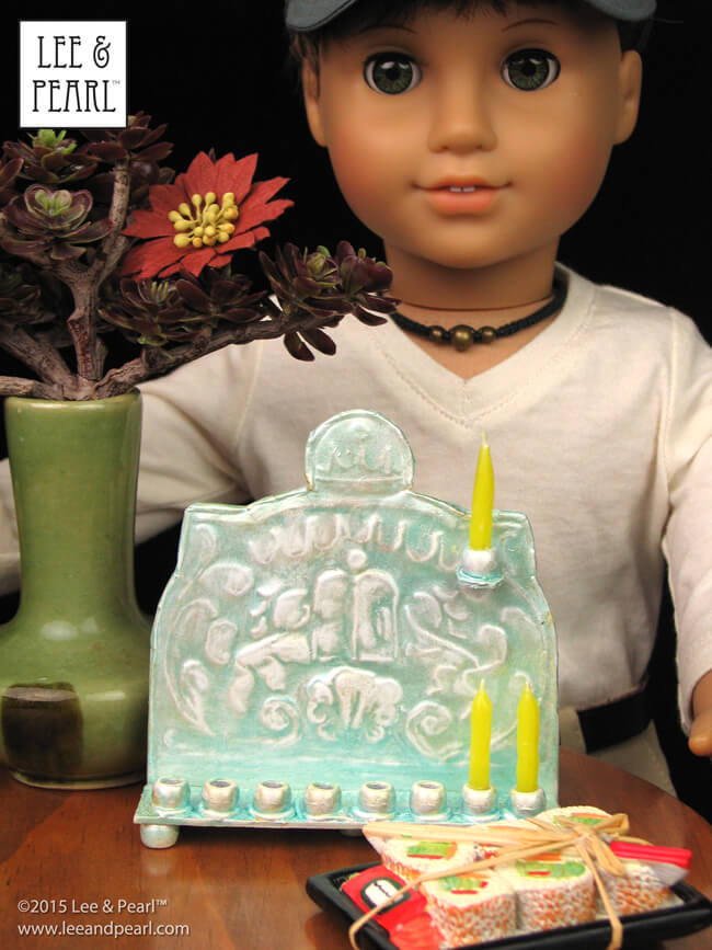 Happy Chanukah from Lee & Pearl! Make your 18 inch dolls their very own pressed metal Chanukah Menorah (Chanukiya) using a dollar store cookie sheet, cardboard, glue, plastic beads, a knitting needle, metallic paints and the techniques in our easy VIDEO TUTORIAL.